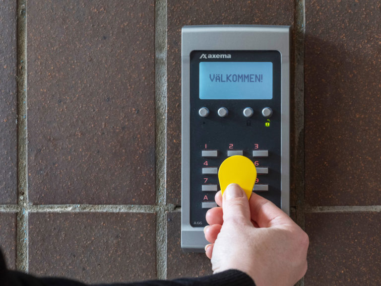 Tagg som hålls framför Axema Passersystem